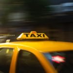 panning photography of yellow taxi